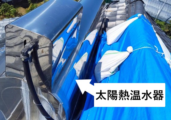 地震で被災した瓦屋根に載っている太陽熱温水器