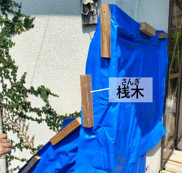 外壁のブルーシート養生　桟木で押さえている