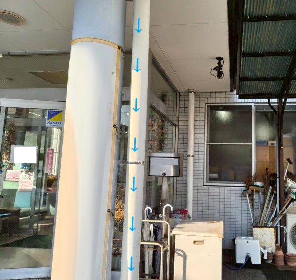 屋根から流れてきた雨水が竪樋を流れてくる