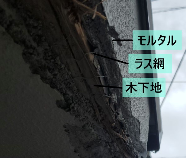 庇屋根のモルタルが削れてラス網や木下地がむき出しになっている