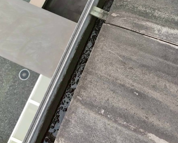 泥が詰まって雨水が滞留している軒樋