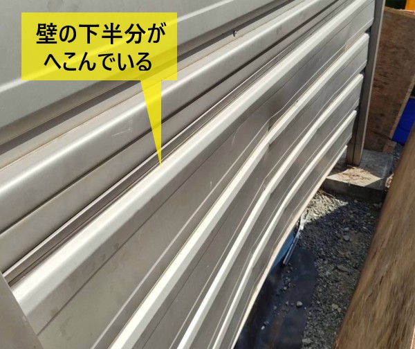 物置の壁の下半分がへこんでいる