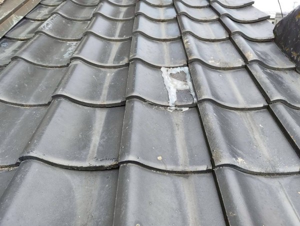 瓦が割れてコーキングがべったり塗られている