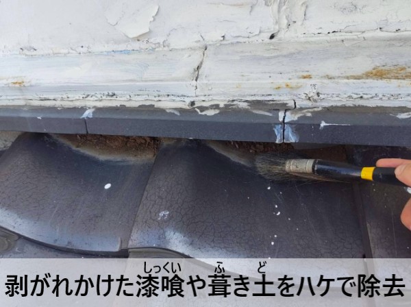 面戸の剥がれかけた漆喰や葺き土をハケで除去している